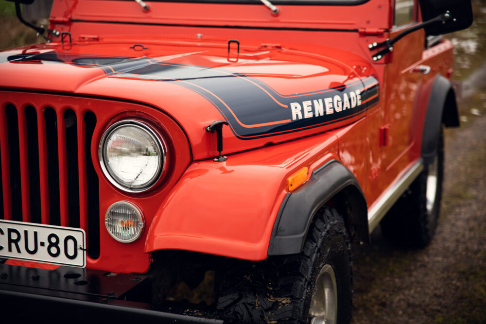 Red vintage Jeep Renegade on a forest road