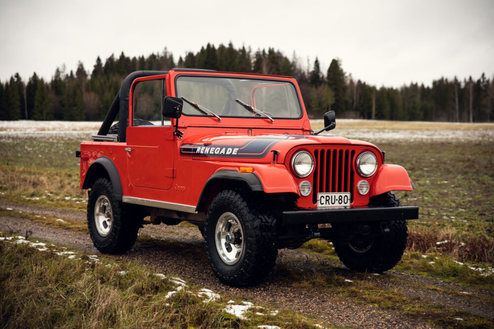 Red Jeep Renegade on misty forest field