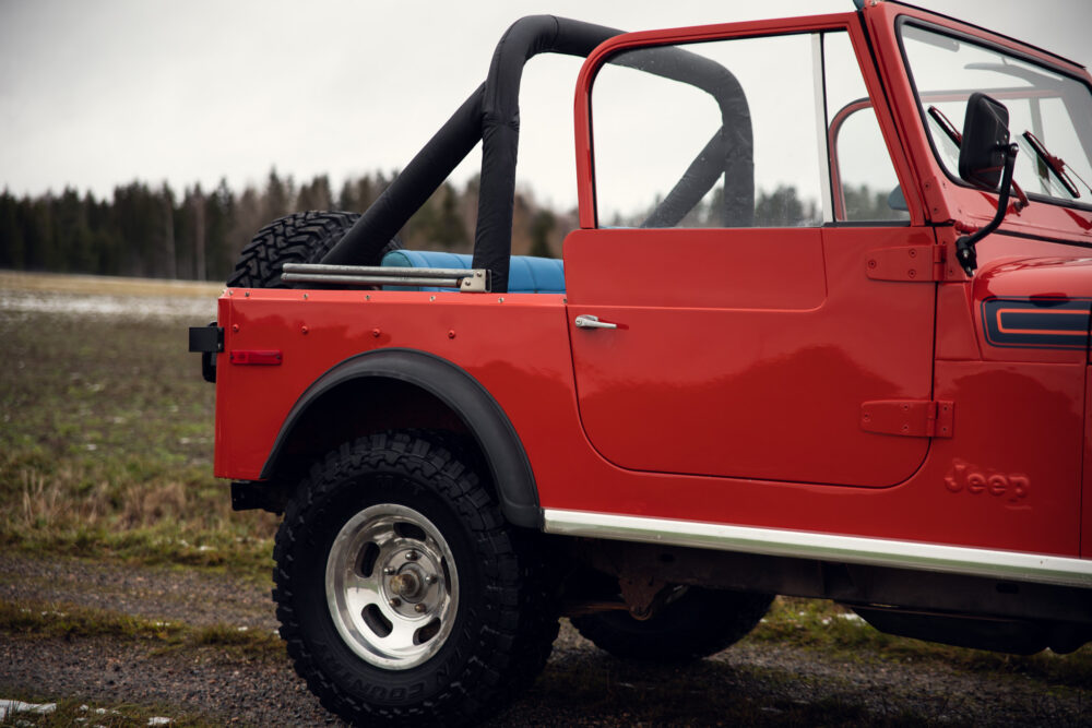 Red Jeep vehicle parked outdoors in a field