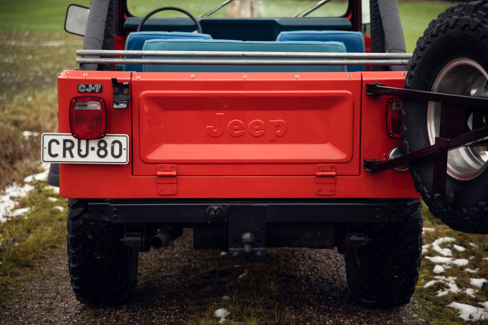 Red Jeep CJ-7 rear view with exposed tire