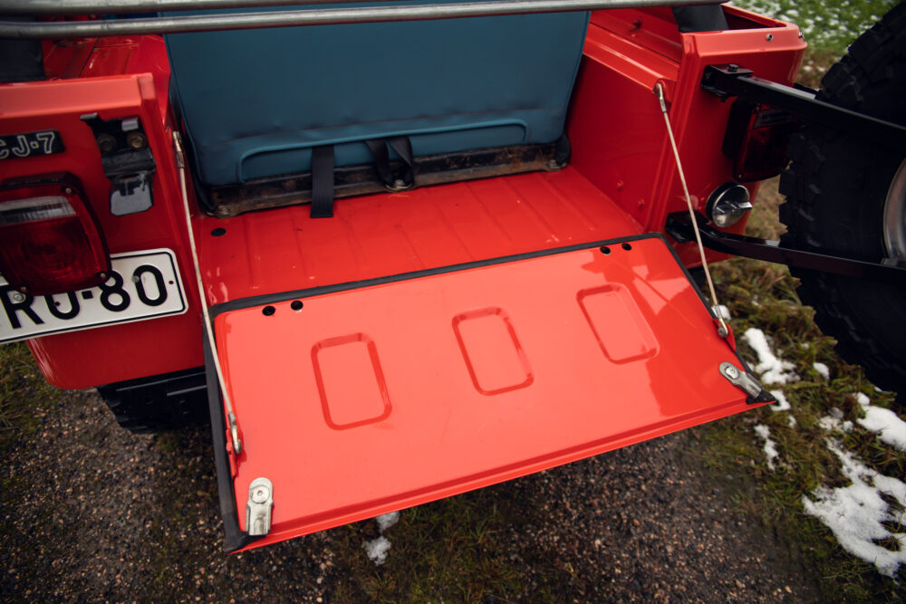 Red off-road vehicle's open rear gate on snowy ground