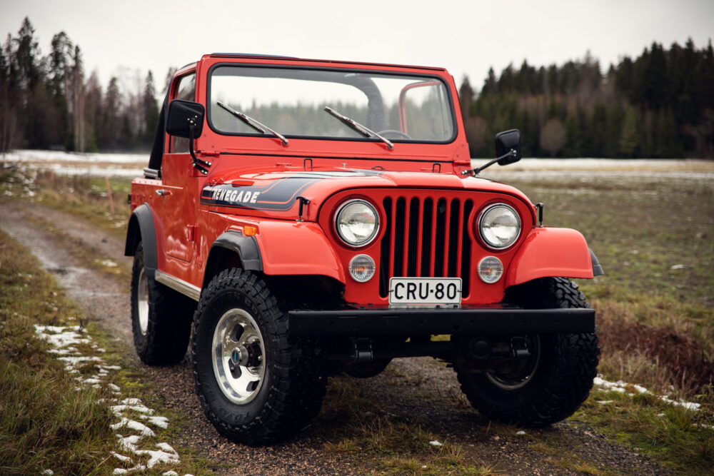 Red vintage Jeep Renegade on snowy forest road