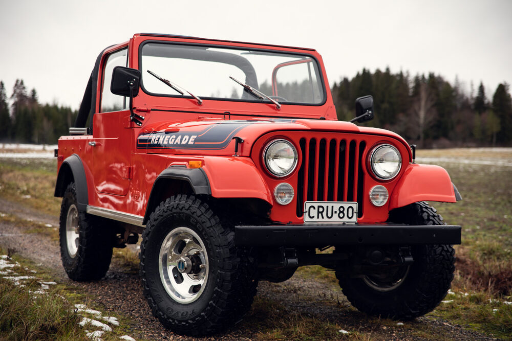 Red vintage Jeep Renegade on a forest road