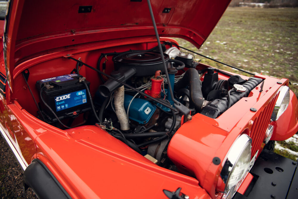 Red vintage car engine bay open showing components