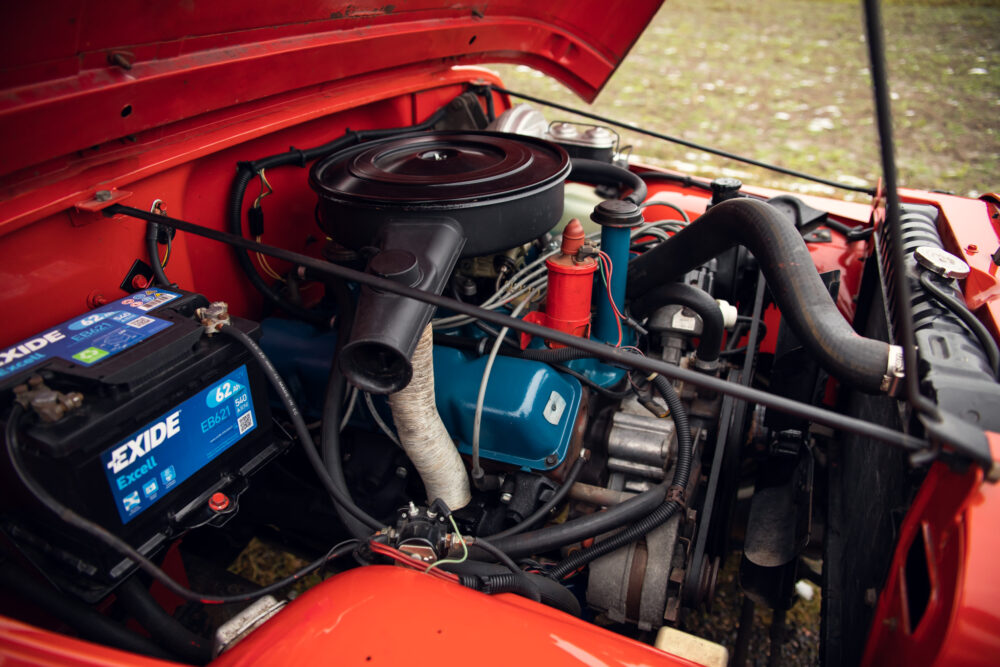 Detailed view of a red car's open engine compartment