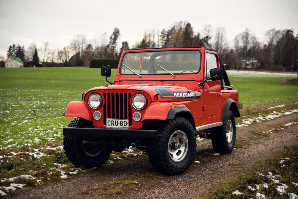 Red Jeep Renegade on snowy grass field