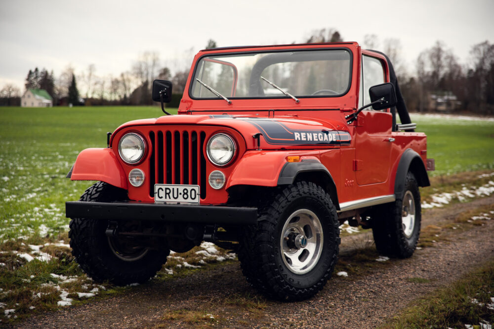 Red vintage Jeep Renegade on rural field