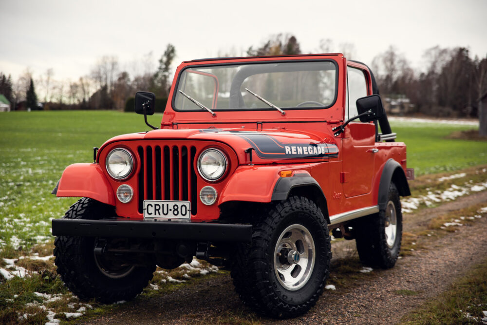 Red Jeep Renegade on grassy field