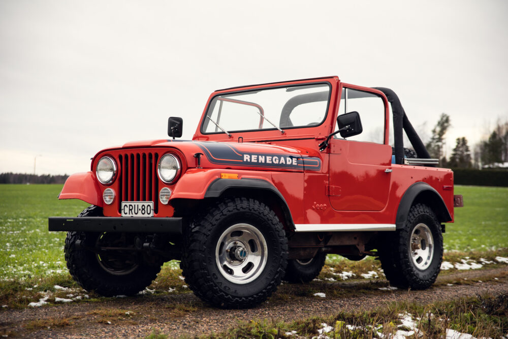 Red Jeep Renegade parked on grass field