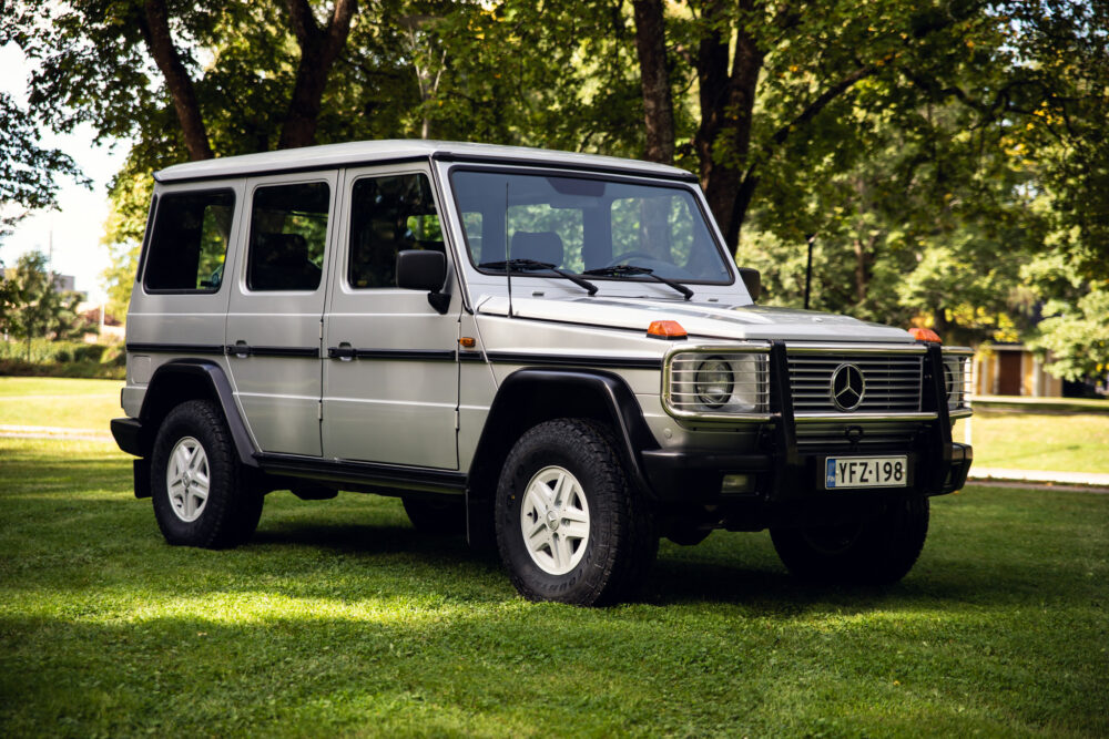 Silver Mercedes SUV parked on grass in park