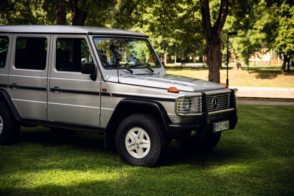 Silver Mercedes SUV parked in a sunny park