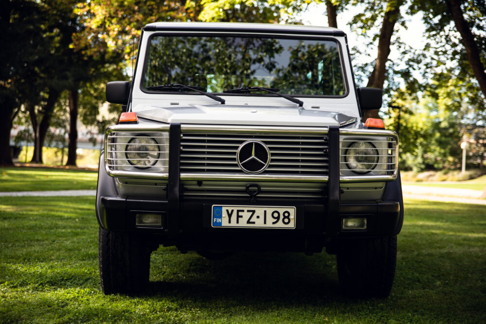 Mercedes SUV parked on grass in sunny park