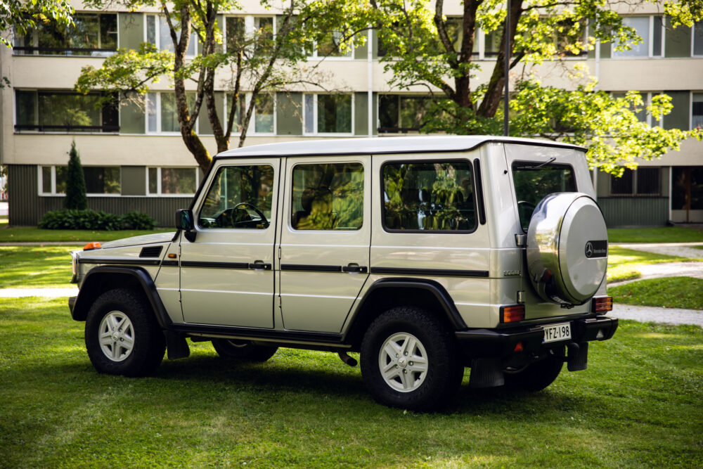 SUV parked on green grass outside modern buildings