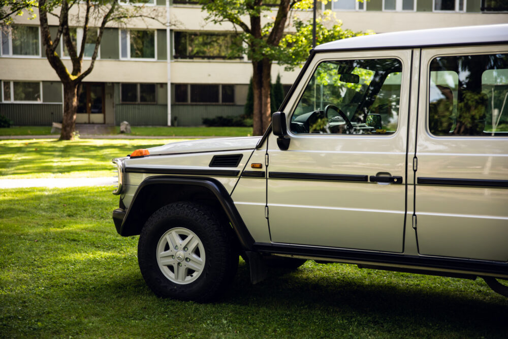 White SUV parked on grass near modern building