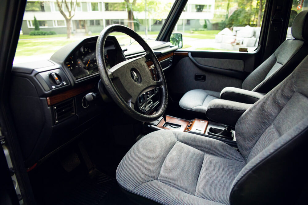 Vintage car interior with wooden accents and steering wheel.