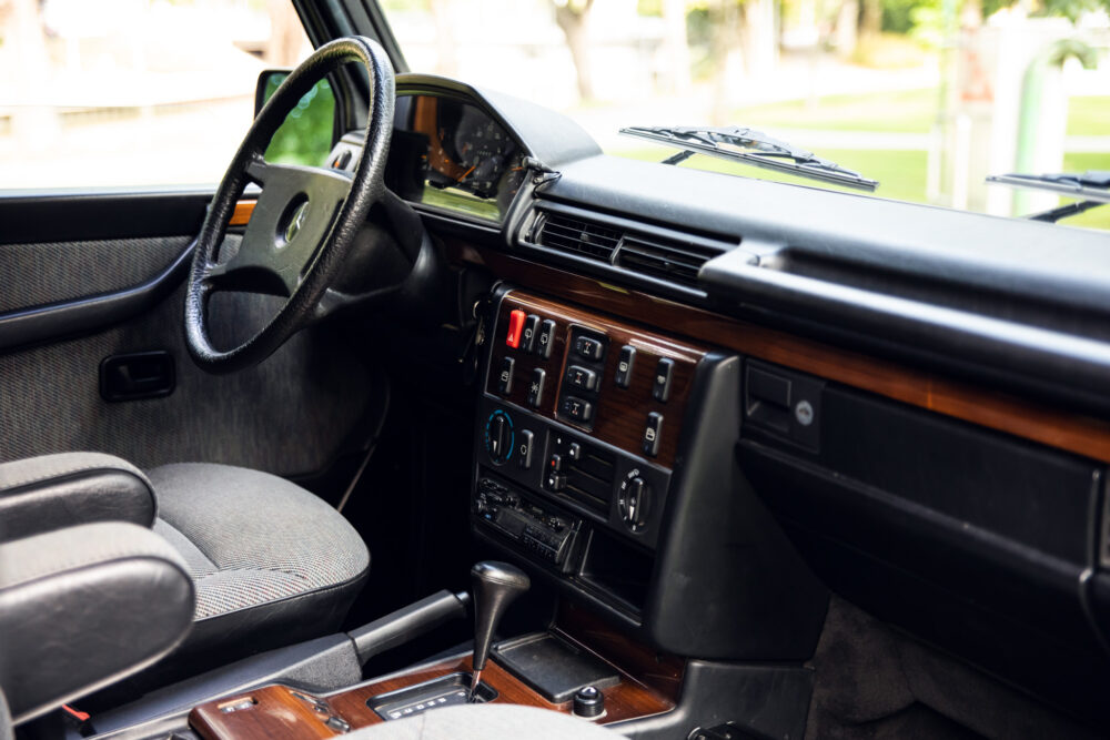 Vintage car interior with wooden dashboard and steering wheel