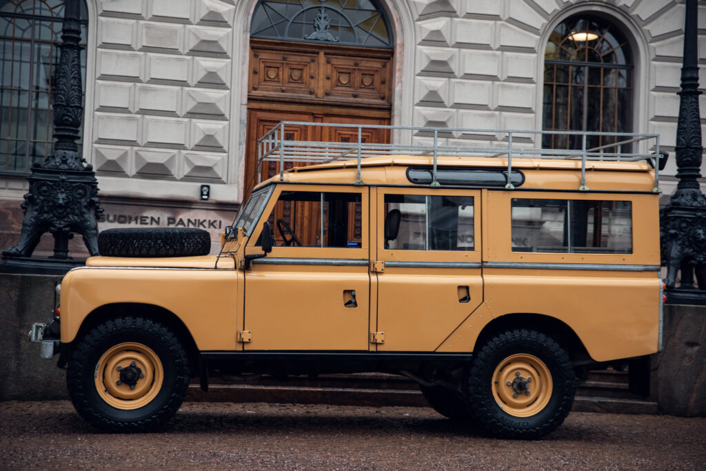 Yellow vintage SUV parked near historical building