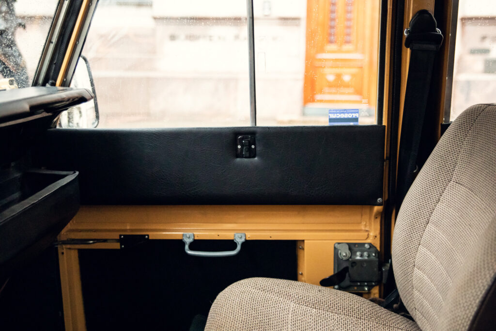 Interior view of old vehicle door and passenger seat.