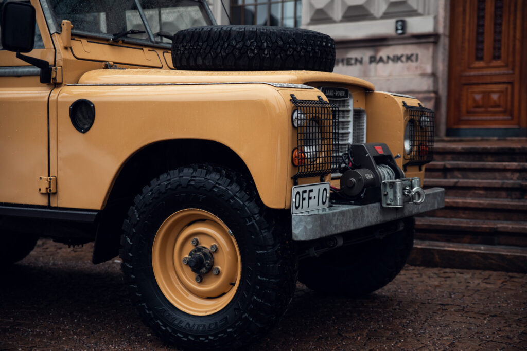 Yellow Land Rover Defender parked near building