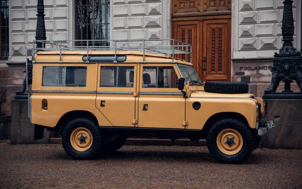 Yellow Land Rover near historic building entrance