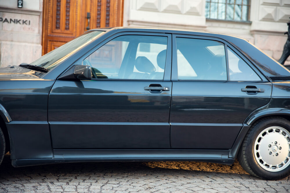 Vintage black car parked on cobblestone street