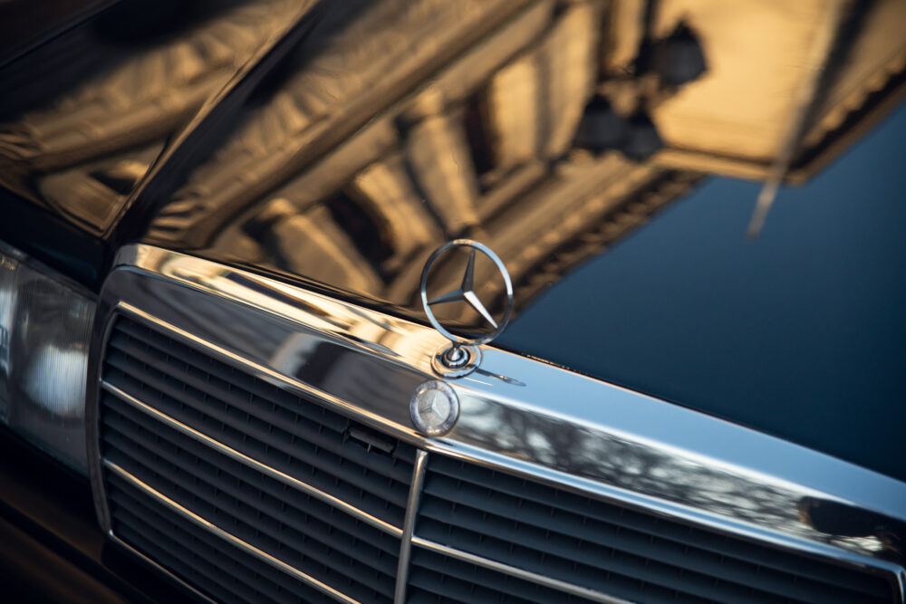 Mercedes emblem on grille with reflective building