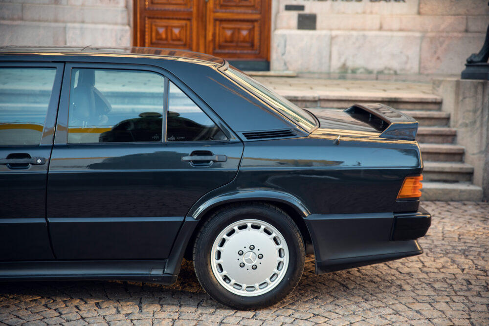 Classic black sports car parked by stone steps