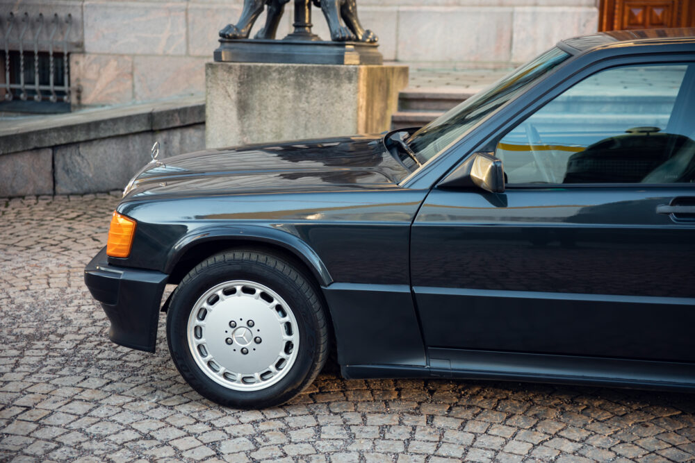 Black vintage Mercedes parked near statue