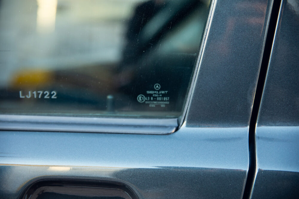 Close-up of car window etching with serial number