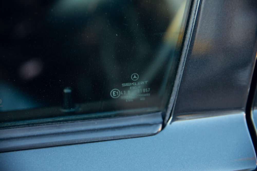 Car window corner showing Sekurit brand logo and details