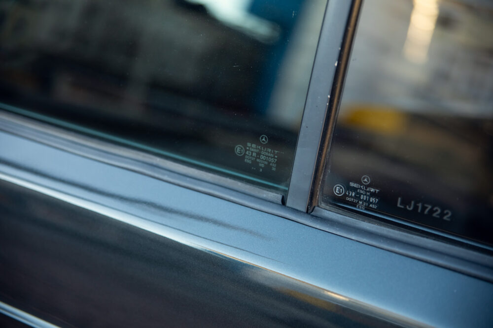 Close-up of car window corner with safety markings