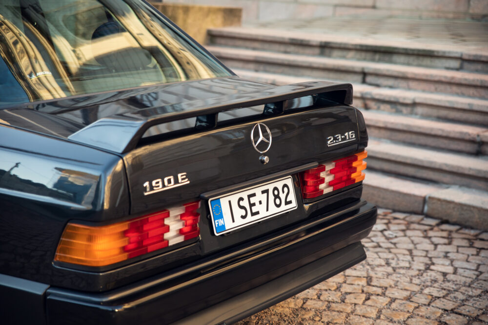 Black Mercedes 190E parked near cobblestone steps