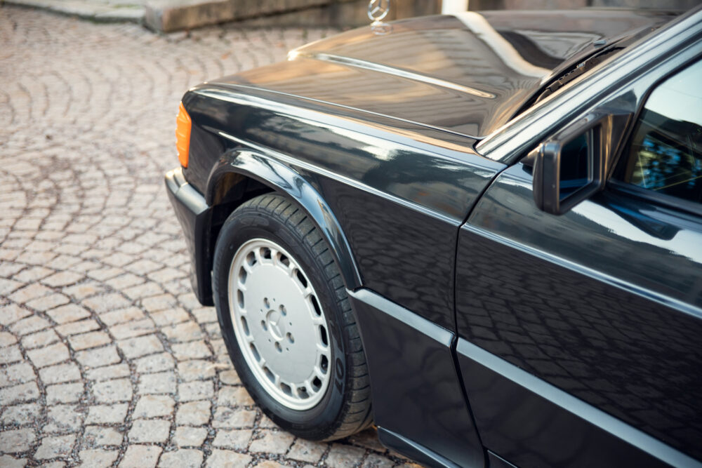 Classic black car parked on cobblestone street