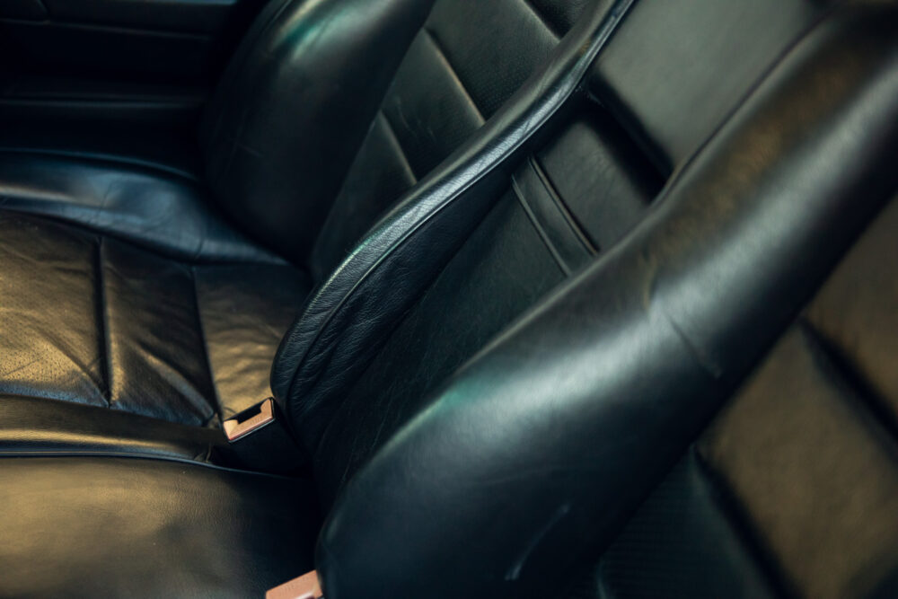 Close-up of worn black leather car seat