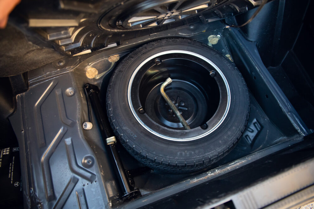 Spare tire stored in car trunk compartment