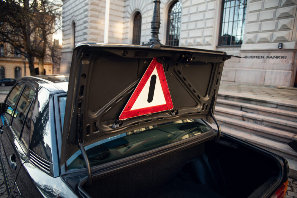 Warning triangle in car trunk against urban background