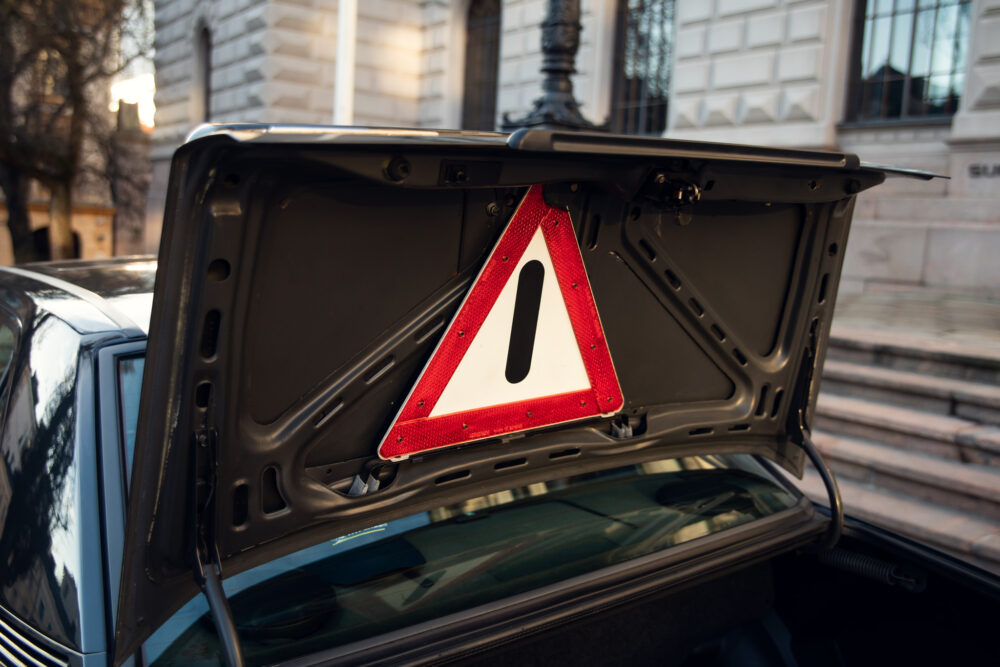 Exclamation warning sign in car trunk by historical building