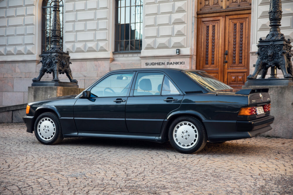 Vintage Mercedes-Benz 190E parked by historic building