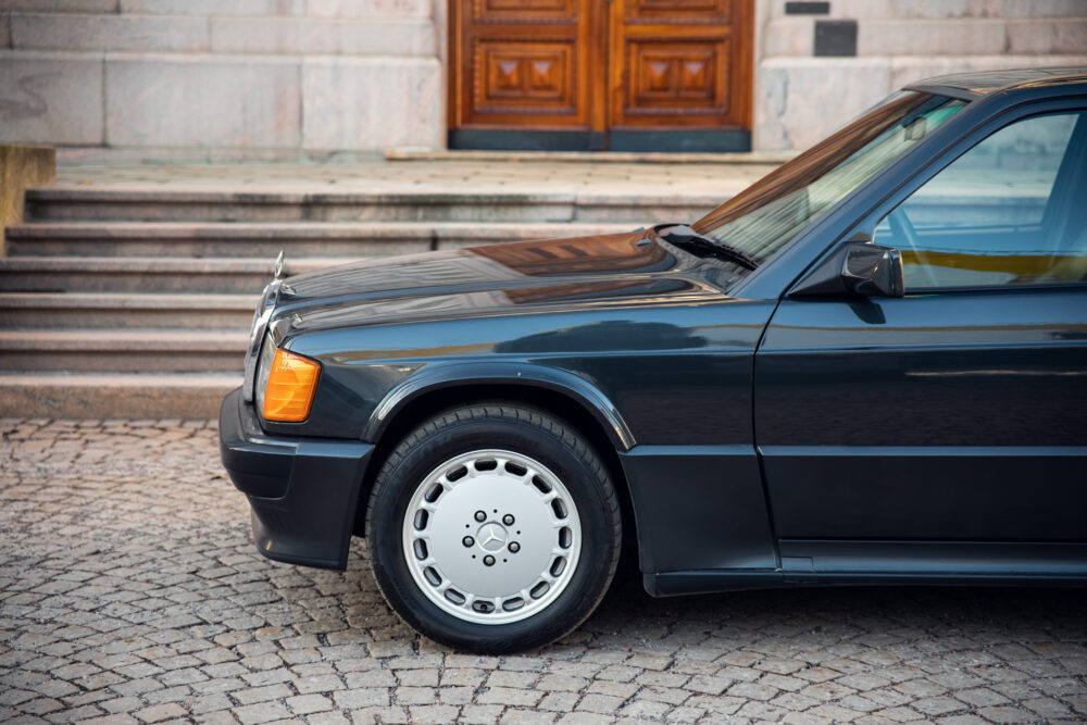 Vintage black car parked near stone steps and door