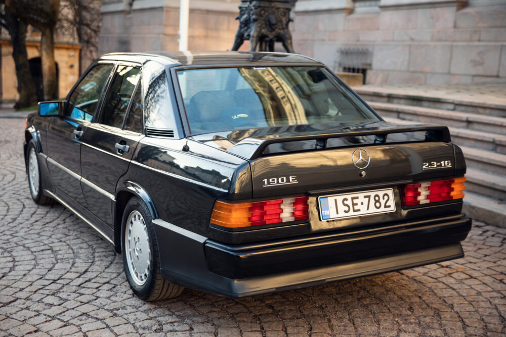 Vintage black Mercedes 190E parked on cobblestone street