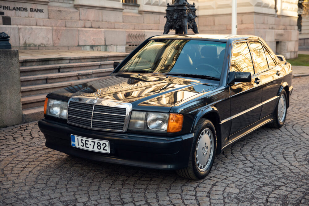 Vintage black Mercedes parked near historic stone building