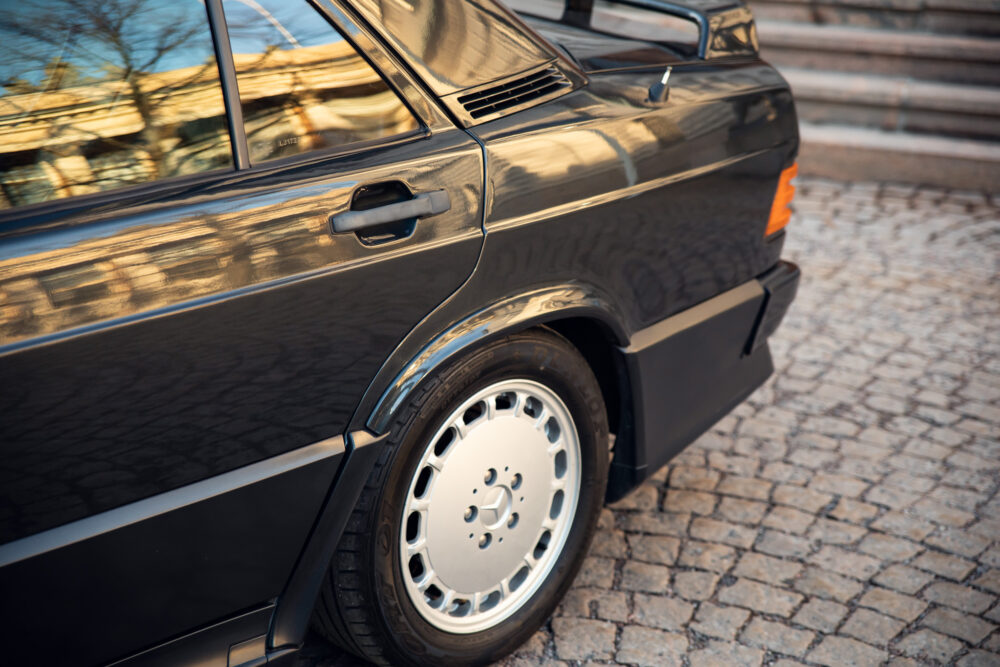 Vintage black car parked on cobblestone street