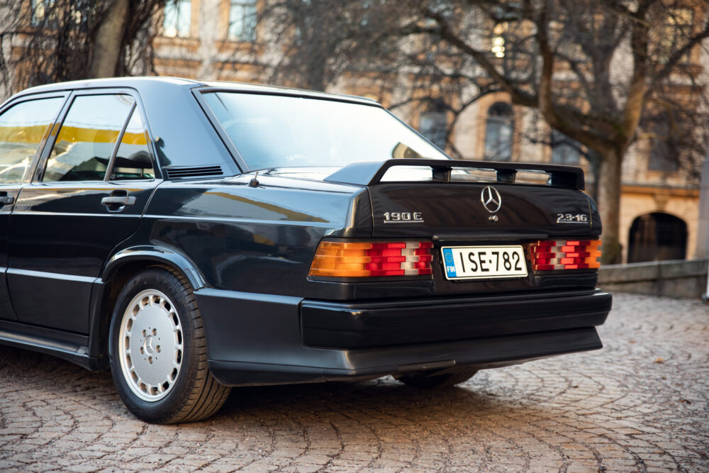 Vintage black Mercedes 190E parked on cobblestone street