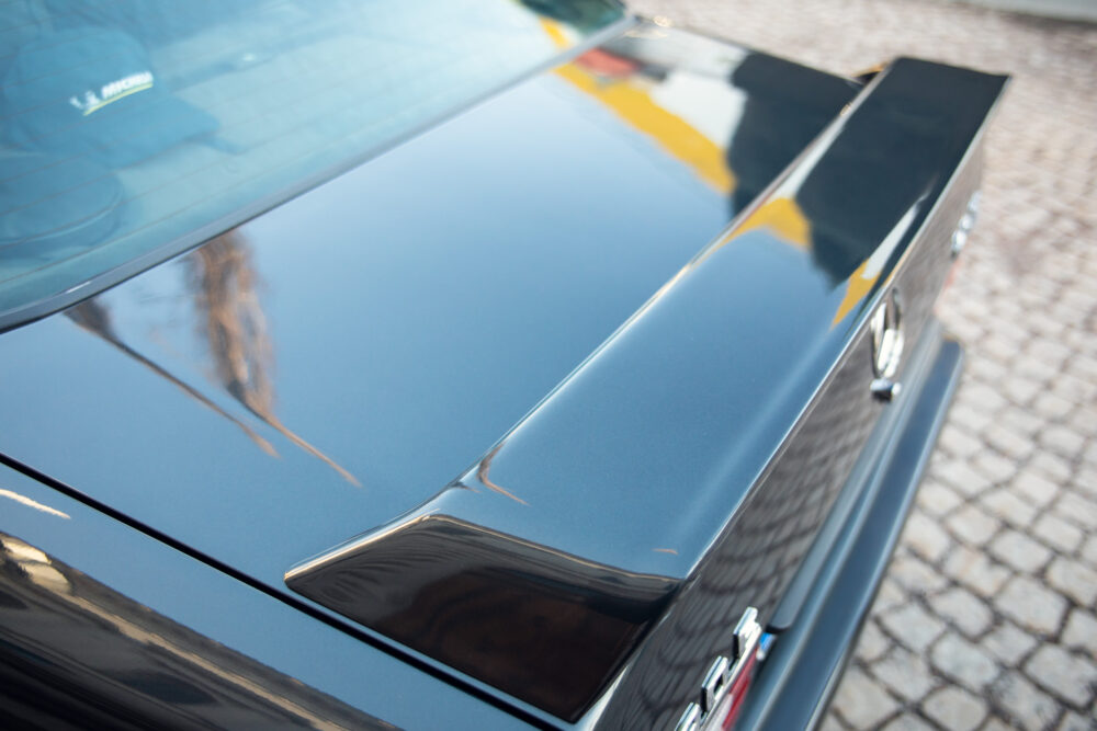 Close-up of blue car hood and shiny chrome details