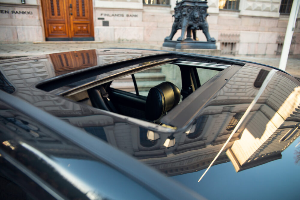 Car roof reflecting architecture and statue