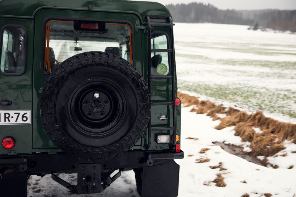 Green SUV with spare tire on snowy field