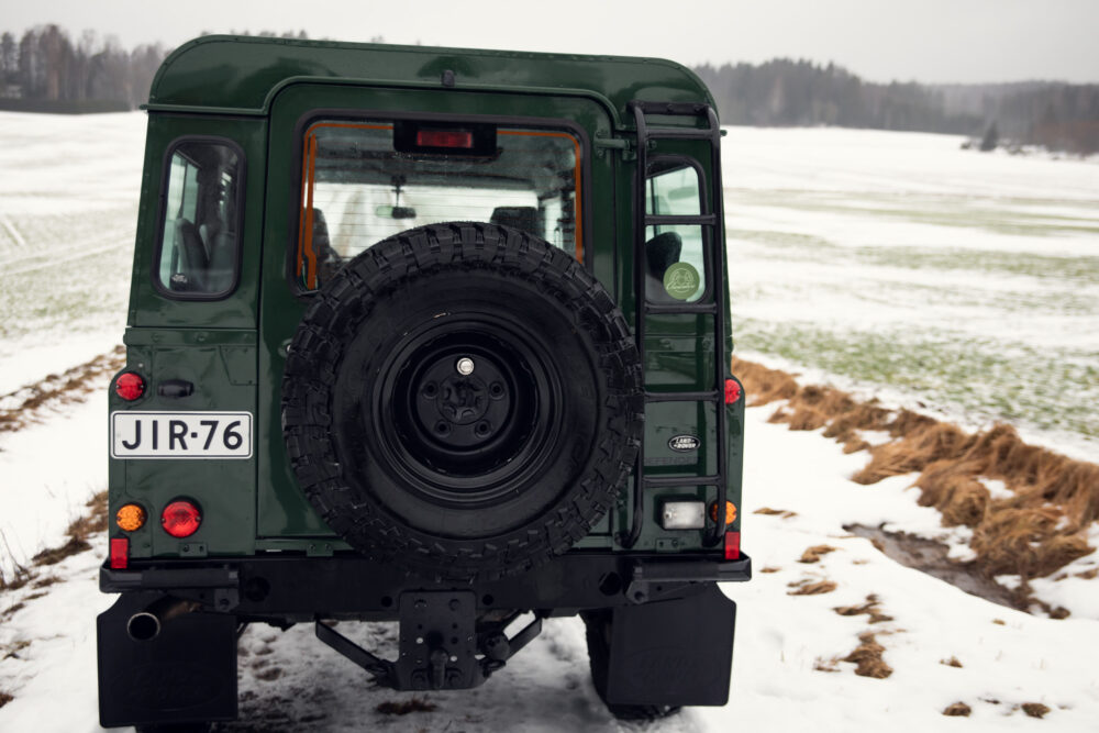 Green SUV with spare tire on snowy field