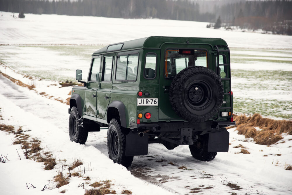 Green SUV on snowy rural road