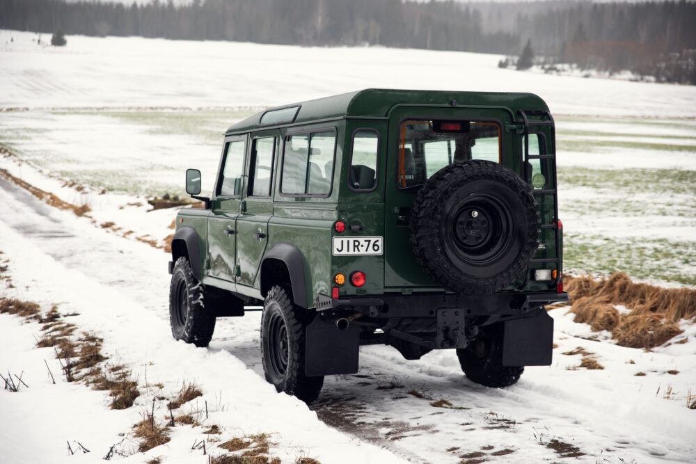 Green SUV on snowy rural road