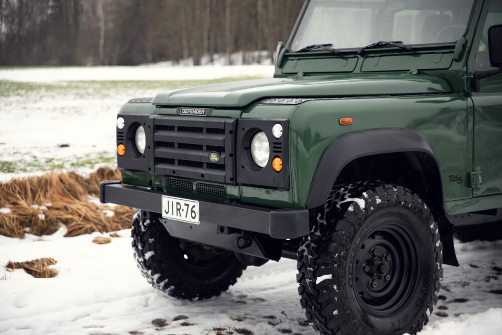 Green Land Rover Defender on snowy field